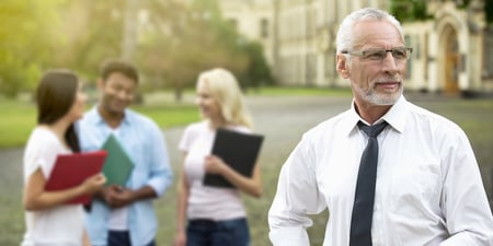 Educator looking in the distance with students behind him