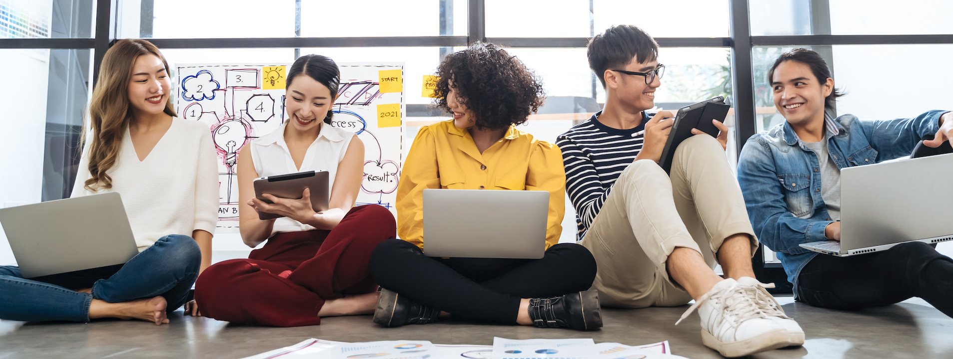 Students sitting on the floor of a hallway