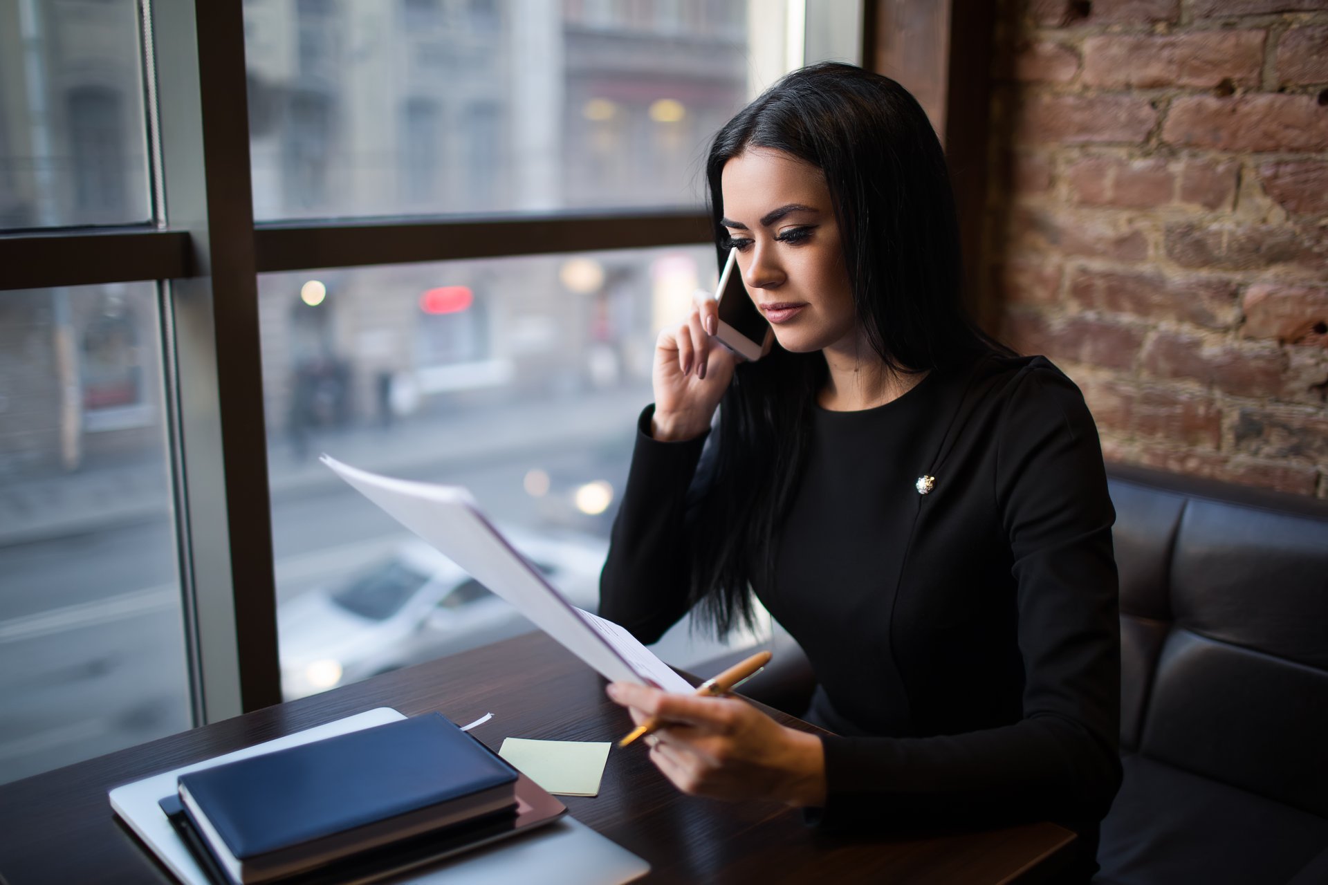 Woman talking on a phone while reading papers